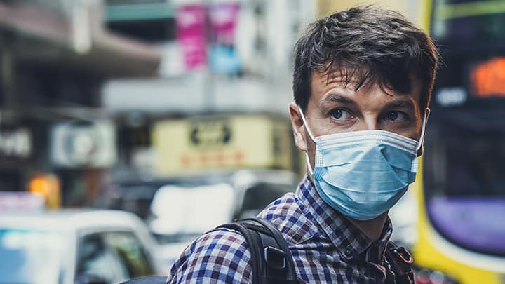 Person in city with a mask on