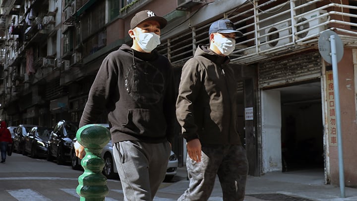 Two Men In Masks Walk On The Street