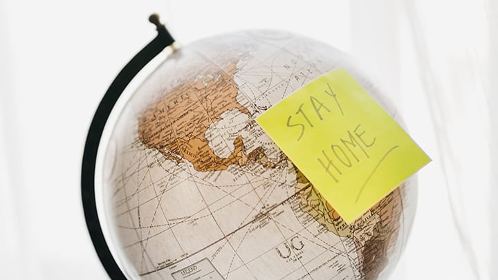 Globe with note saying "Stay Home"