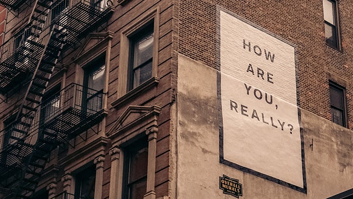 Sign on building with words, "How are you really?"
