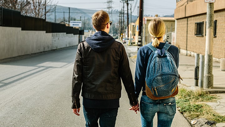 Two people walking down a street