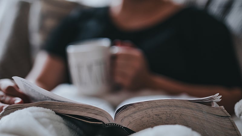 Woman drinking coffee and reading Bible