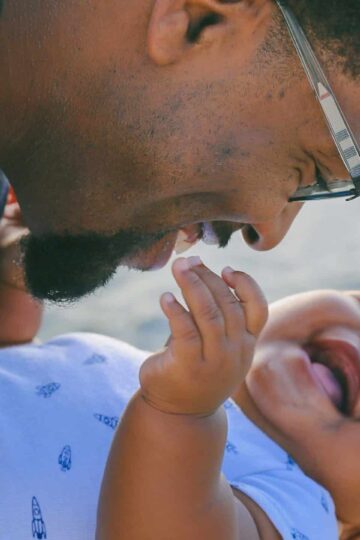 Father holding laughing baby