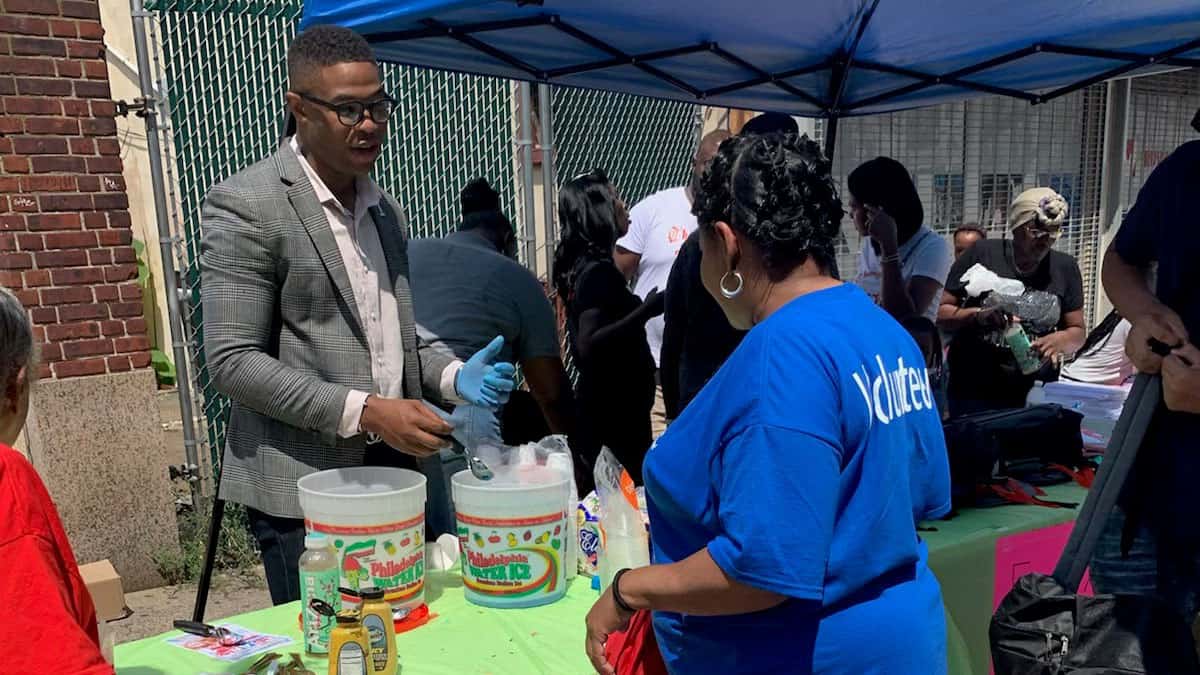 Pastor Juwan Bennett serving water ice at outreach event