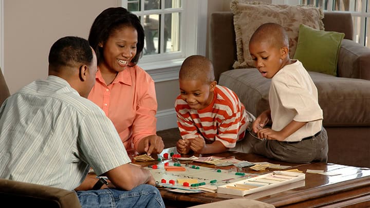 Family with two sons playing Monopoly